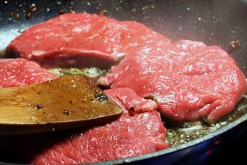 Raw sirloin beef steaks on frying pan.