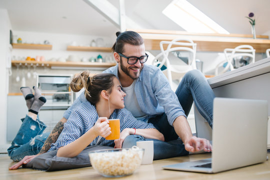 Young couple watching movie on laptop at home 