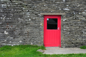 A small red door in slate wall