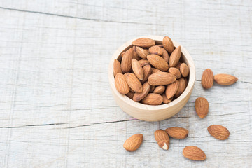 Almonds in a bowl on old wood background. Healthy food
