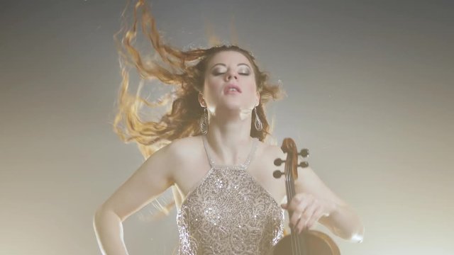 concert of classic music, Famous female playing on viola at recital in darkness in flashing light and haze