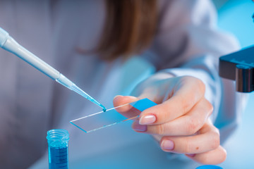 female technician take sample on microscope slide