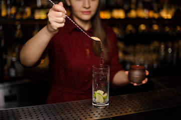 barmaid prepares a mojito in a crystal glass