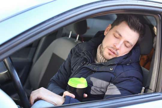 Tired Man With Cup Of Coffee Inside Car In Traffic Jam