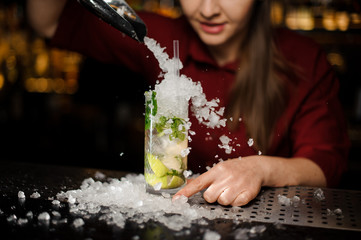 barmaid adds to mojito crushed ice