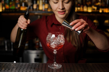 barman girl at a bar counter prepares an alcoholic cocktail Spritz Veneziano
