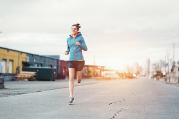 Woman athlete jogging in city industrial area