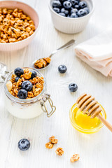 Fitness breakfast with granola and honey on white background