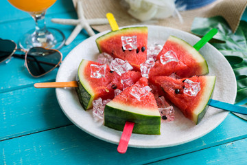 Watermelon slice popsicles with colorful stick on wooden background, Summer fruits