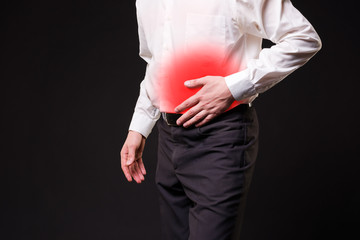 Man with abdominal pain, stomach ache on black background