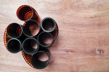 Old twisted 35 mm negative film strip on the brown wooden background with copy space