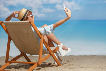 A girl on the beach sunbathing in a chaise lounger. Summer mood. Vacation.