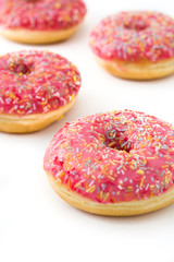 Pink frosted donut with colorful sprinkles isolated on white background