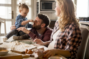Obraz na płótnie Canvas Happy family making pasta in the kitchen at home