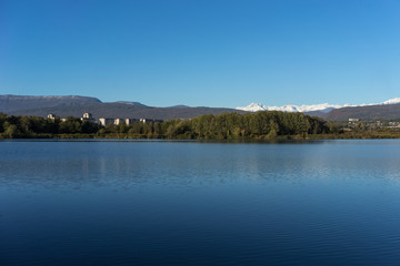 Landscape with a beautiful lake surrounded by houses and vegetation.