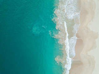 Top view of beautiful white sand beach and turquoise sea water, aerial drone shot. Amazing nature background.