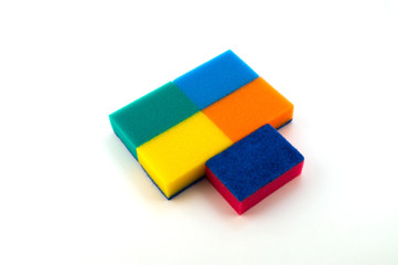 Разноцветные губки для мытья и чистки, четыре уложены вверх поролоном, одна – тонким абразивным слоем.