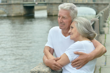  senior couple on city street near river