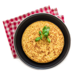 Spanish potato omelet (tortilla de patatas) isolated on white background in a frying pan, top view