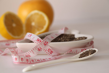 Dieting concept. Closeup grapefruit fruit with measuring tape ,  almond , oats and chia on white background 