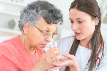 Obraz na płótnie Canvas helping old lady to take her medication