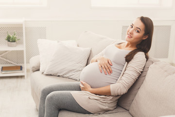 Obraz na płótnie Canvas Smiling pregnant woman dreaming about child