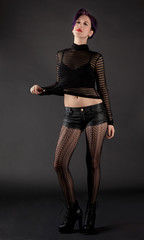 Woman in Sheer Top, Leather Shorts, Patterned Tights, and High Heeled Boots