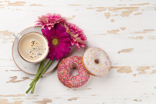 Coffee cup, donuts and gerbera flowers