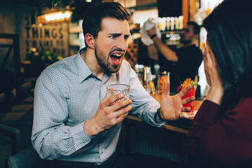 A picture of guy screaming to the girl. He is tired and angry at the same time. She is stressed as...