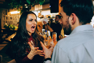 Girl is screaming to the guy. She is unhappy, sad and stressed. The guy is trying to defence himself.