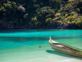 Wooden boat in blue sea and white sand beach in summer day for travel and holiday concept.