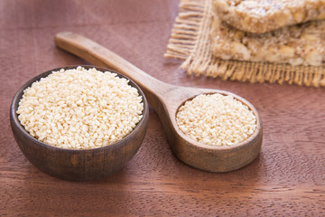 White sesame seeds on wooden background