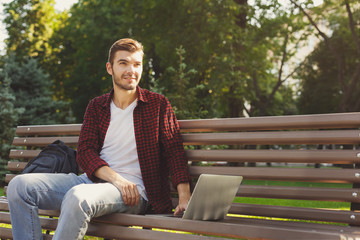 Fototapeta premium A smiling man with laptop outdoors