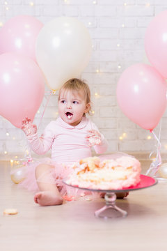 first birthday celebration - funny little girl eating and smashing cake