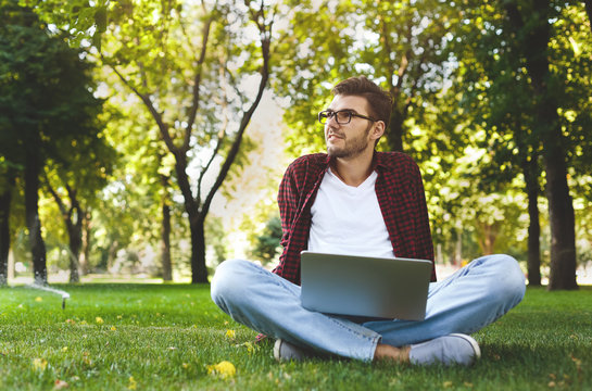 Handsome young man using a laptop outdoors