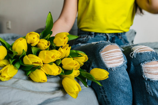 Fototapeta woman hold bouquet of yellow tulips. romantic flowers knees