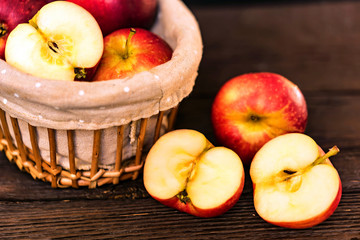 Red juicy apples and halves in basket close