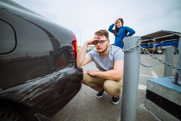 man with sad look on scratched car. woman with sorry look near d
