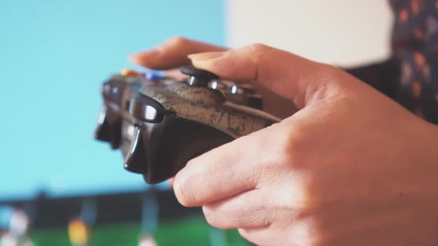 Woman playing computer games with a joystick.