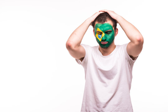 Upset loser fan support of Brazil national team with painted face isolated on white background