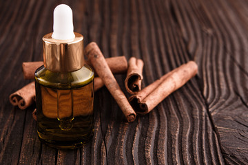 Obraz na płótnie Canvas Cinnamon essential oil on a wooden background