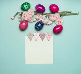 fresh spring beautiful narcissus, with Easter eggs lined with a frame on a light blue background, with a festive greeting card, space for text flat lay pastel shades