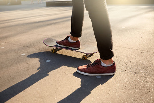 Close-up of skateboarders feet while skating in skate park. Man riding on skateboard. Isolated view, low angle shot.