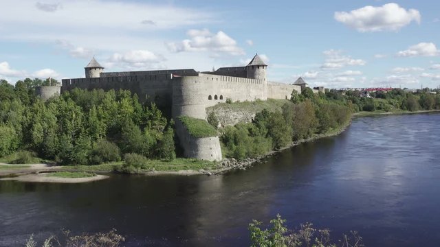 Beautiful cityscape, medieval touristic attraction on Russian Estonian border, Ivangorod fortress on banks of Narva river, cloudy sky horizon
