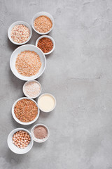 Background with various cereals and beans in white plates