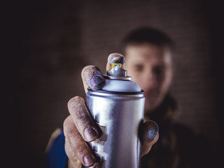 street art artist holding spray paint can in the hand close up