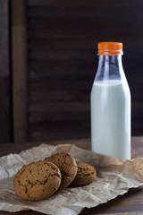 homemade cookies and milk bottle wooden background