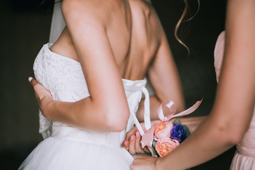 Obraz na płótnie Canvas bridesmaid laces a wedding dress
