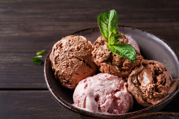 Portion of ice cream scoops with fruit on wood