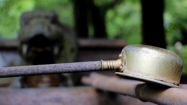 Change focusing at a ladle at the well with a water spout, shrine at Osaka castle area, Japan